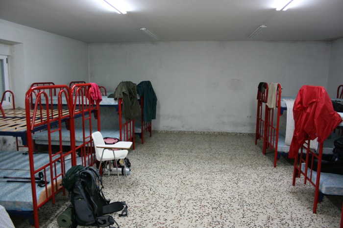 Rote Gitterbetten in einem kargen Übernachtungsraum